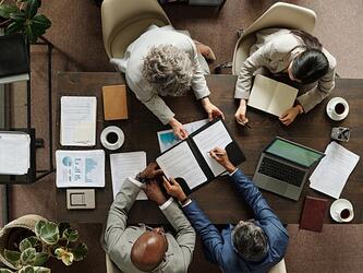 business leaders sit around table planning